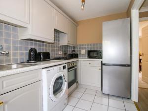 a kitchen with a washer and a white refrigerator at 18 Hengrave Meadow in Telford