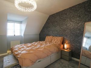 a bedroom with a bed and a chandelier at 18 Hengrave Meadow in Telford