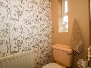 a bathroom with a toilet with a flowery shower curtain at 18 Hengrave Meadow in Telford +24 photos
