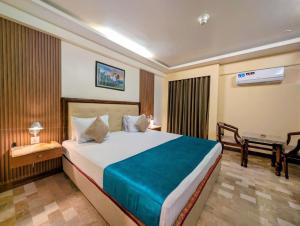 a bedroom with a large bed in a room at Hotel Galaxy in Karachi