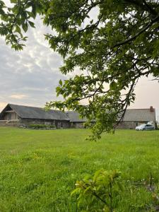 a field of green grass with a building in the background at Grandma's Attic in Saraiķi
