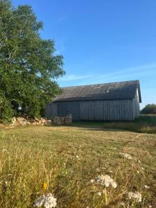an old barn in the middle of a field at Grandma's Attic in Saraiķi