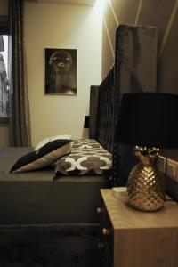 a bedroom with a bed and a table with a lamp at Dorian Gray Luxury Suite in Trieste +1 photo