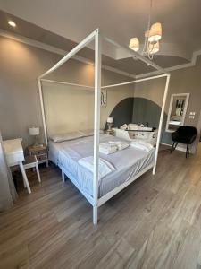 a white canopy bed in a room with wooden floors at Dorian Gray Luxury Suite in Trieste