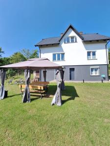 a picnic table under a large umbrella in a yard at Apartament Alicja in Chmielno