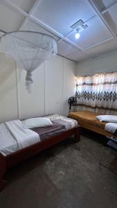 a bedroom with two beds and a ceiling with a window at Crystal Hostels in Livingstone