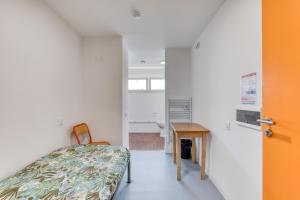 a small room with a bed and a table at Résidence Arkenciel 1 in Mudaison