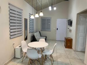 a dining room with a table and white chairs at Casa Colibrí Volcán in Volcán