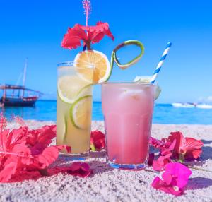 two cocktails on the beach with a view of the ocean at Sansi Kendwa Beach Resort in Kendwa