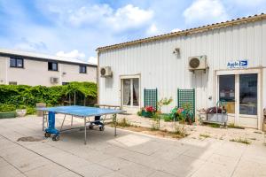 a ping pong table in front of a building at Résidence Arkenciel 1 in Mudaison
