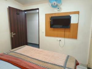 a bedroom with a bed with a flat screen tv on the wall at Hotel Tokyo in Bathinda