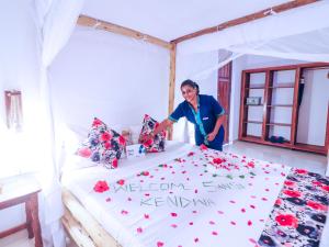 a woman standing next to a bed with flowers on it at Sansi Kendwa Beach Resort in Kendwa +111 photos