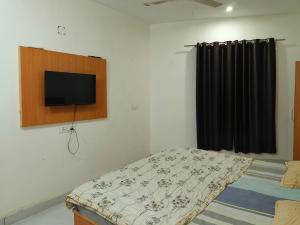 a bedroom with a bed and a flat screen tv on the wall at Hotel Tokyo in Bathinda