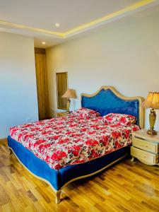 a bedroom with a blue bed with a red blanket at Snowra heights in Abbottabad