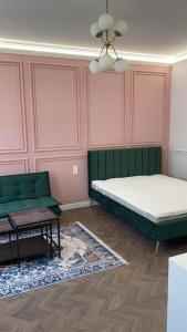 a bedroom with a bed and a couch and a table at Cozy Modern Studio in Debrecen +7 photos