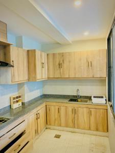 a kitchen with wooden cabinets and a sink at Snowra heights in Abbottabad