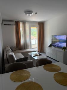 a living room with a couch and a flat screen tv at Panamera Luxury Apartment Ilidža in Sarajevo
