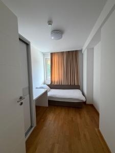 a small room with a bed and a window at Panamera Luxury Apartment Ilidža in Sarajevo