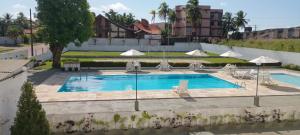 a large swimming pool with chairs and umbrellas at Hotel San Conrado in Salinópolis +33 photos