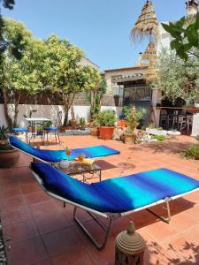 a patio with two blue chairs and a table at El Patio in Darnius