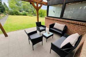 a patio with chairs and a couch and a table at Ferienhaus Adler in Unterlüß