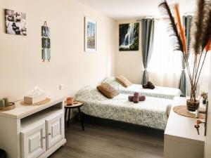 a bedroom with two beds and a desk and a window at La Diligence in Lepin-le-Lac