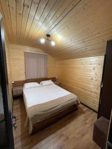 a bedroom with a large bed in a wooden room at ARBAT house LUXURY in Arbatʼ