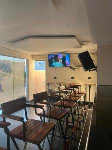 a room with a row of chairs and a flat screen tv at Ravens nests lodge in Livingstone