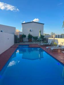 a swimming pool in front of a house at Ravens nests lodge in Livingstone