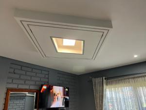 a coffered ceiling with a television in a room at Nduna Legacy Lodge in Harare