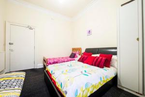 a bedroom with a large bed with red pillows at Edinburgh Morrison Central ApartHotel in Edinburgh