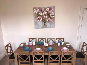 a dining room table with chairs and a painting on the wall at Edinburgh Morrison Central ApartHotel in Edinburgh