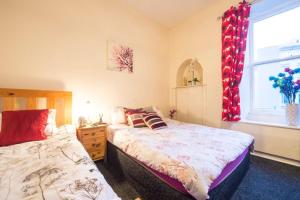 a bedroom with two beds and a window at Edinburgh Morrison Central ApartHotel in Edinburgh