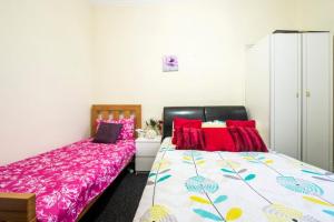 a bedroom with two beds with red pillows at Edinburgh Morrison Central ApartHotel in Edinburgh