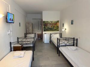 a group of four beds in a room at Summer Time in Ios Chora