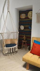 a swing in a room with a couch and a table at Mirador in Beja