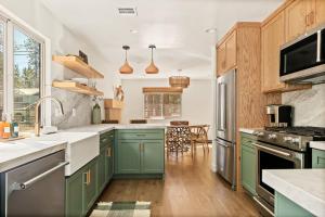 a kitchen with green cabinets and a sink at Modern Hideaway in Big Bear in Big Bear City