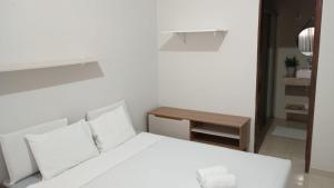 a bedroom with a white bed and a small table at Hotel San Conrado in Salinópolis