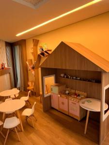 a room with two tables and a kitchen with a house at Refúgio Azul de Porto in Porto De Galinhas