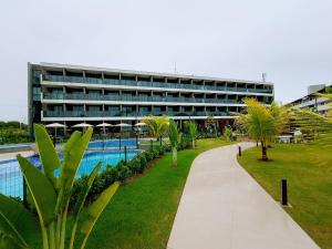 a large building with a swimming pool and palm trees at Refúgio Azul de Porto in Porto De Galinhas +20 photos