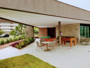 a patio with tables and chairs and a pool table at Refúgio Azul de Porto in Porto De Galinhas