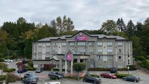 a hotel with cars parked in a parking lot at Coast Abbotsford Hotel & Suites in Abbotsford