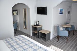 a hotel room with a bed and a desk and a table at North West Castle Hotel in Stranraer