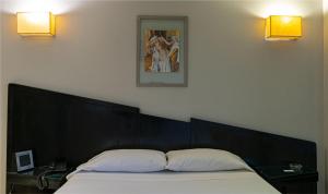 a bed with two pillows in a bedroom with two lights at Hotel Css in Ituzaingó +1 photo