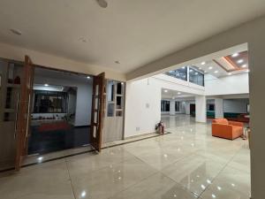 an empty lobby with an open door and a couch at Yashoda Inn in Ormānjhi