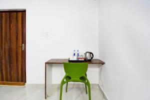 a table with a green chair in a room at Hotel O Grand 55 in Bālianta