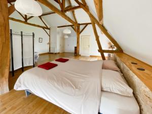 ein großes weißes Bett in einem Zimmer mit Holzboden in der Unterkunft Chambre d'Hotes Cugnac in Sainte-Sabine