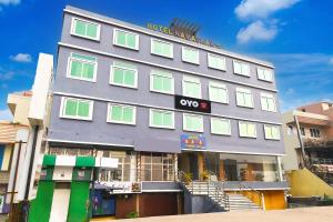 a building with green and white windows on it at Hotel O Grand 55 in Bālianta +21 photos