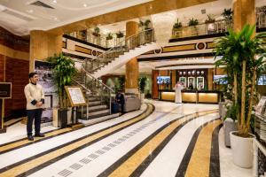 a man stands in the lobby of a shopping mall at Golden Tulip Al Shakreen in Medina