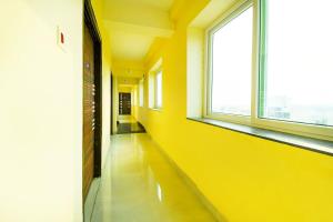 an empty hallway with a yellow wall and windows at Hotel O Grand 55 in Bālianta